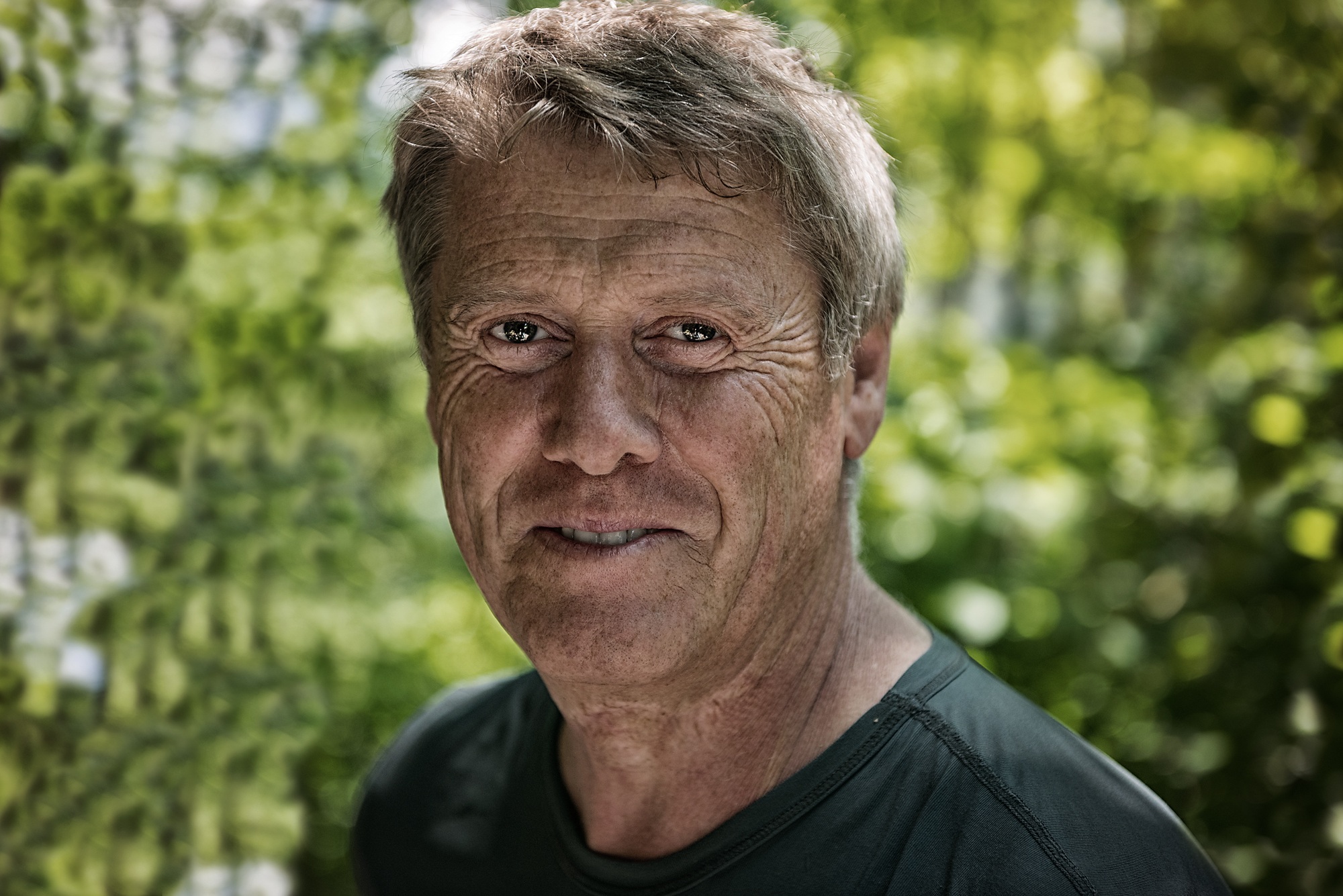 An older man smiling outdoors